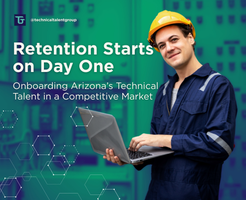 Engineer in a safety helmet using a laptop inside a Phoenix manufacturing facility, representing onboarding Arizona technical talent and workforce retention.