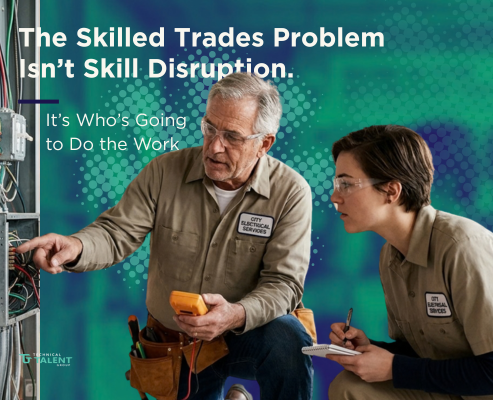 An experienced senior electrician with safety glasses points out details on an open electrical breaker panel while training a younger female apprentice taking notes.
